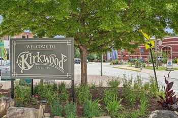 A sign that says "Welcome to Kirkwood" is in front of a tree.